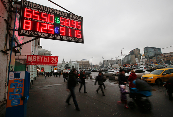 People walk past boards showing currency exchange rates in Moscow, December 17, 2014. The dramatic fall in Russia's rouble slowed on Wednesday, with the government selling foreign currency to prop it up after a 50 percent fall against the dollar this year. (Reuters / Maxim Zmeyev)