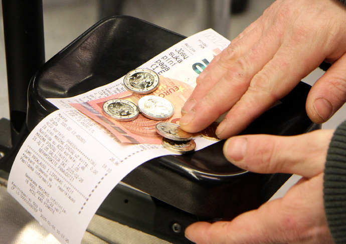 A customer pays in euro banknotes in a supermarket in Vilnius on January 1, 2015. (AFP Photo / Petras Malukas)
