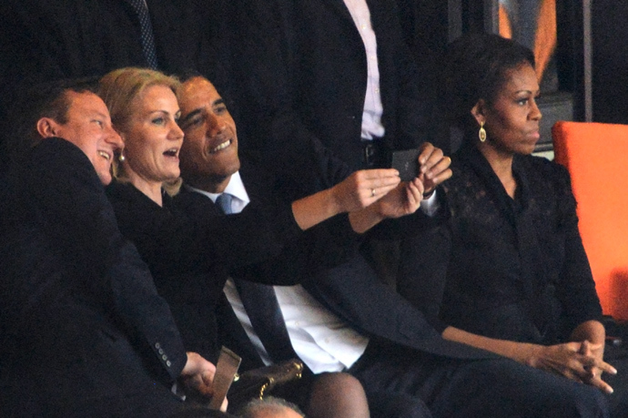 US President Barack Obama (R) and British Prime Minister David Cameron pose for a selfie picture with Denmark's Prime Minister Helle Thorning Schmidt (C) next to US First Lady Michelle Obama (R) during the memorial service of South African former president Nelson Mandela at the FNB Stadium (Soccer City) in Johannesburg on December 10, 2013 (AFP Photo)