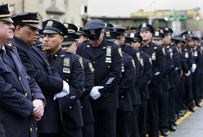 Law enforcement officers stand, with some turning their backs, as New York City Mayor Bill de Blasio speaks on a monitor outside the funeral for NYPD officer Wenjian Liu in the Brooklyn borough of New York January 4, 2015. (Reuters/Shannon Stapleton)