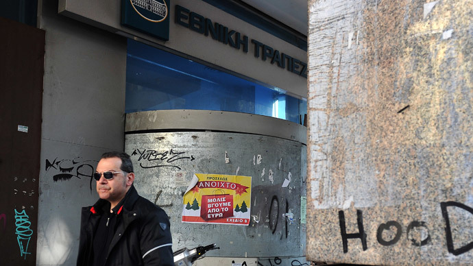 A man walks past a shut down National bank of Greece branch in central Athens, where a placard reads 'Open as soon as we exit the euro' by the 'Plan B ' political party on January 3, 2014. (AFP Photo / Louisa Gouliamaki)