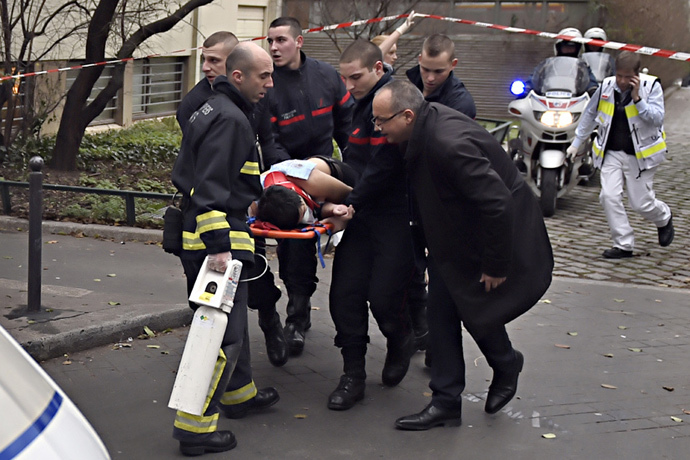 A victim is evacuated on a stretcher on January 7, 2015 after armed gunmen stormed the offices of the French satirical newspaper Charlie Hebdo in Paris, leaving at least 12 people dead. (AFP Photo / Martin Bureau)