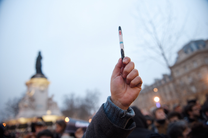 A man raises a pen during a rally at the Place de la Republique in Paris, on January 7, 2015 (AFP Photo / Martin Bureau)
