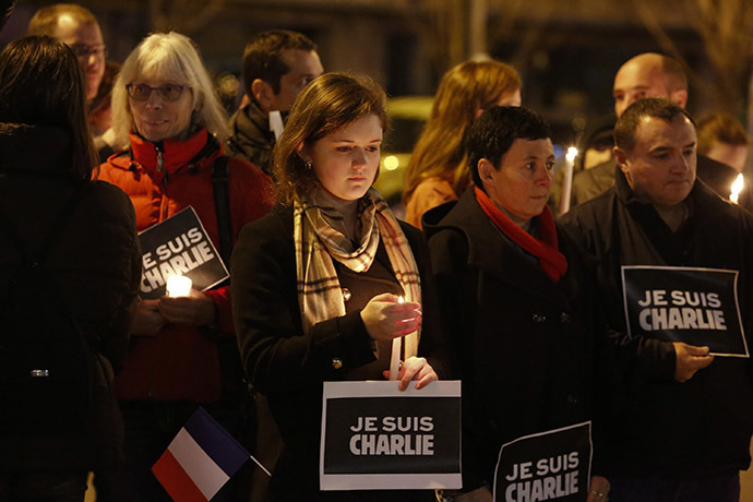 People hold a vigil for the victims of the shooting at the Paris offices of the publication Charlie Hebdo outside the French consulate in Seattle, Washington January 7, 2015. (Reuters/Jason Redmond)