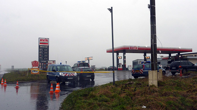French Gendarmerie cars are parked behind a police cordon at an Avia gas station in Villers-Cotterets, north-east of Paris, on January 8, 2015, where the two armed suspects from the attack on French satirical weekly newspaper Charlie Hebdo were spotted in a gray Clio.(AFP Photo/Francois Becker)