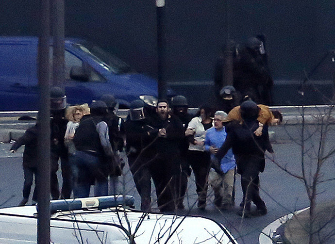 Police evacuate hostages after launching the assault at a kosher grocery store in Porte de Vincennes, eastern Paris, on January 9, 2015. (AFP Photo/Thomas Samson)