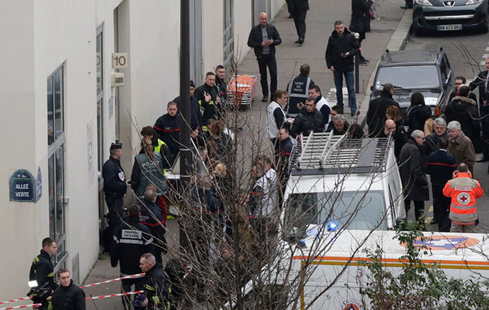 Firefighters and rescue members stand in front of the Paris offices of Charlie Hebdo, a satirical newspaper, after a shooting January 7, 2015 (Reuters / Philippe Wojazer)