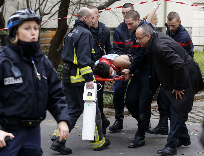 Firefighters carry a victim on a stretcher at the scene after a shooting at the Paris offices of Charlie Hebdo, a satirical newspaper, January 7, 2015. (Reuters/Jacky Naegelen)