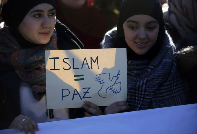 Two young women hold a placard that reads "Islam = Peace" in Madrid on January 11, 2015. (Reuters)