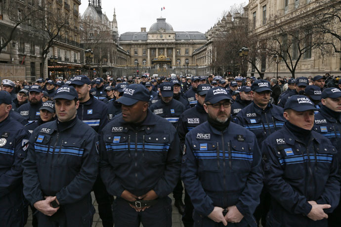 French municipal Police officers react as they attend a national tribute for the three officers killed during last week's terrorist attacks, in front of Paris Prefecture, January 13, 2015. (Reuters/Gonzalo Fuentes)