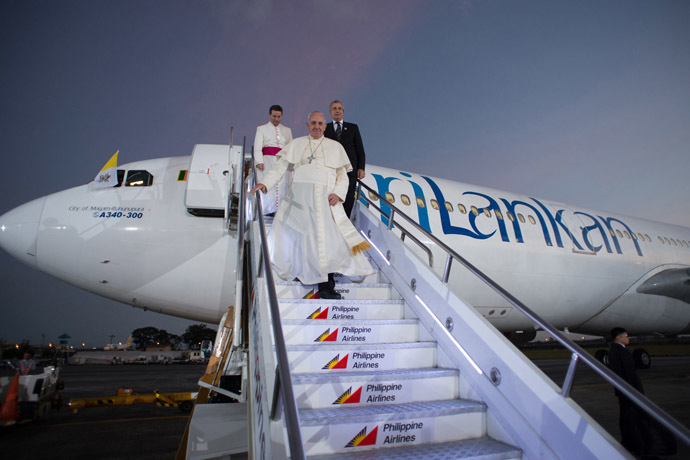 In this handout picture released by the Vatican press office (Osservatore Romano), Pope Francis (C) arrives in the Philippines in Manila on January 15, 2015. (AFP Photo/Osservatore Romano)