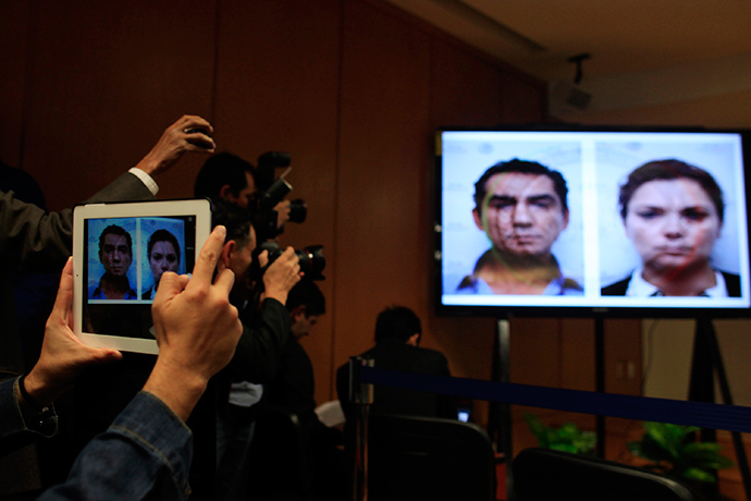Media take pictures of mugshots of Jose Luis Abarca, former mayor of Iguala, and his wife Maria de los Angeles displayed on a screen during a news conference in Mexico City December 7, 2014 (Reuters / Carlos Jasso)
