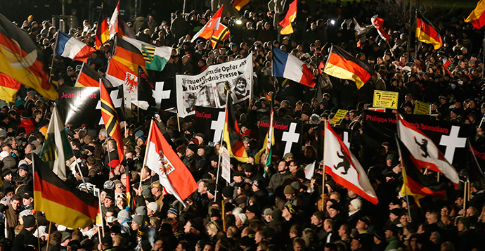 Supporters of anti-immigration movement Patriotic Europeans Against the Islamisation of the West (PEGIDA) hold flags during a demonstration in Dresden January 12, 2015 (Reuters / Fabrizio Bensch)