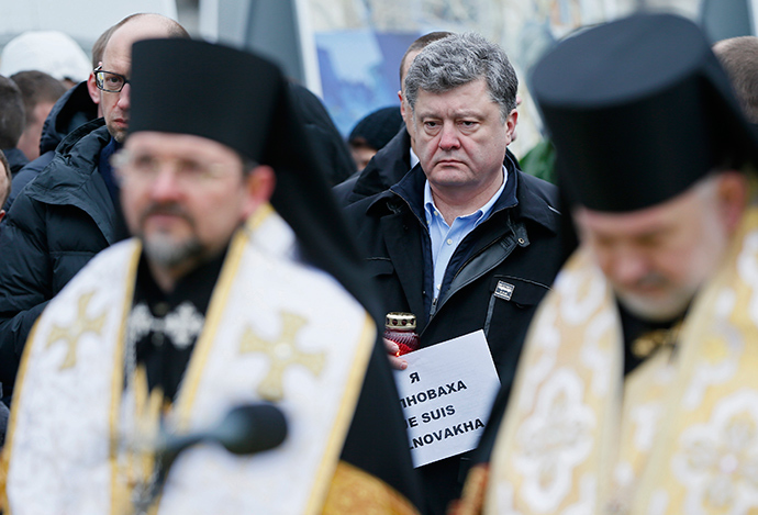 Ukrainian President Petro Poroshenko (C) and Prime Minister Arseny Yatseniuk (hidden L, back) take part in a peace march in tribute to the victims onboard a passenger bus, which came under fire near the town of Volnovakha, in Kiev, January 18, 2015 (Reuters / Gleb Garanich)