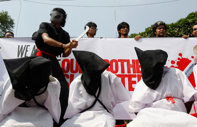 Members of Magic Movement, a group of young Bangladeshis, stage a mock execution scene in protest of Saudi Arabia beheading of eight Bangladeshi workers in front of National Museum in Dhaka (Reuters / Andrew Biraj)