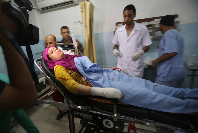 A Palestinian woman who, medics said, was wounded in an Israeli air strike arrives at a hospital in Khan Younis in the southern Gaza Strip July 8, 2014. (Reuters / Ibraheem Abu Mustafa)