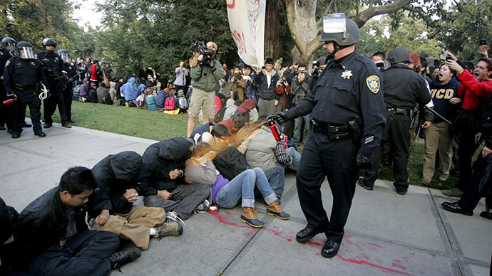 A University of California Davis police officer pepper-sprays students during their sit-in at an "Occupy UCD" demonstration in Davis, California November 18, 201. (Reuters/Brian Nguyen)