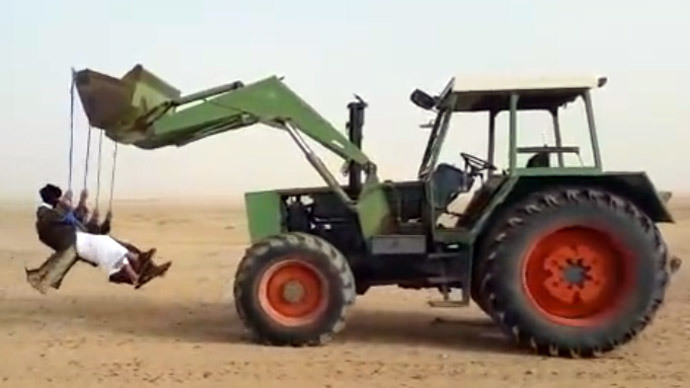 ​Having fun in Saudi desert: Daredevils swinging from reversing tractor (VIDEO)