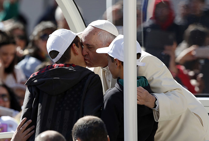 Pope Francis kisses two children, after carrying them onto his Popemobile, before leading his Wednesday general audience in Saint Peter's Square at the Vatican April 16, 2014. (Reuters/Stefano Rellandini)