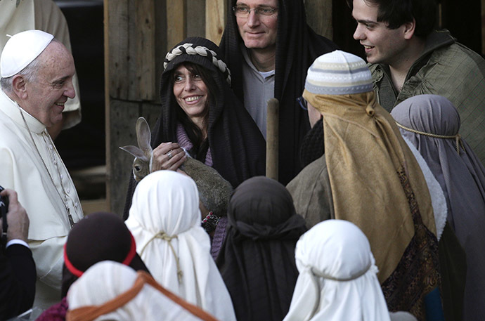 Pope Francis smiles with people dressed as characters from the nativity scene as he arrives to visit the Church of St Alfonso Maria dei Liguori in the outskirts of Rome January 6, 2014. (Reuters/Max Rossi)