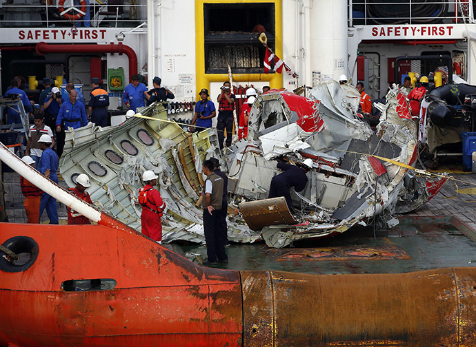 A section of the tail of AirAsia QZ8501 passenger plane is seen on the deck of the ship Crest Onyx, the day after it was lifted from the seabed, as it arrives at Kumai Port, near Pangkalan Bun, central Kalimantan January 11, 2015. (Reuters/Darren Whiteside)