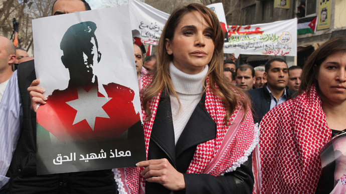 Jordan's Queen Rania holds a picture of recently executed Jordanian pilot Muath al-Kasasbeh, with the words in Arabic reading "Muath is a martyr of right", during a march after Friday prayers in Amman February 6, 2015. (Reuters/Petra News Agency)