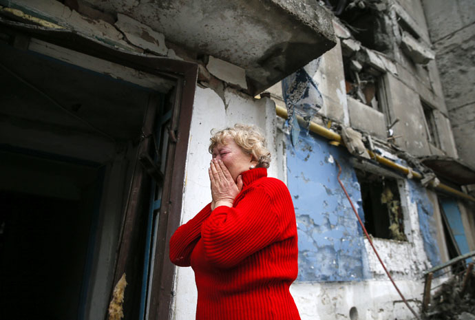 A woman reacts as she stands near a multi-storey block of flats damaged by shelling in Yenakieve town, northeast from Donetsk, February 2, 2015. (Reuters/Maxim Shemetov)