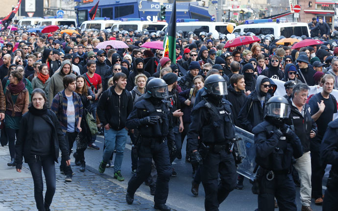 German riot police officers walk along marching protesters in Frankfurt, March 18, 2015. (Reuters/Michael Dalder)