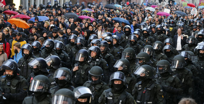German riot police officers walk along marching protesters in Frankfurt, March 18, 2015. (Reuters/Wolfgang Rattay)