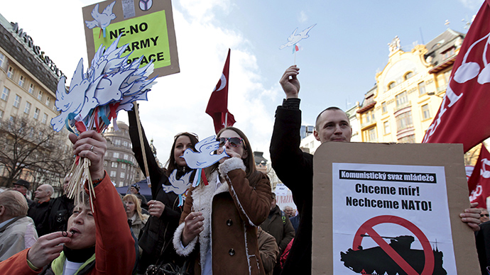 Anti-NATO protesters hold signs and whistles during a demonstration against the U.S. Army's "Dragoon Ride" military exercise in Prague March 28, 2015 (Reuters / David W Cerny)