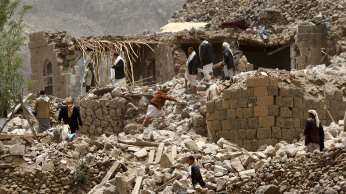 People stand on the rubble of houses destroyed by an air strike in Okash village near Sanaa April 4, 2015. (Reuters/Mohamed al-Sayaghi)