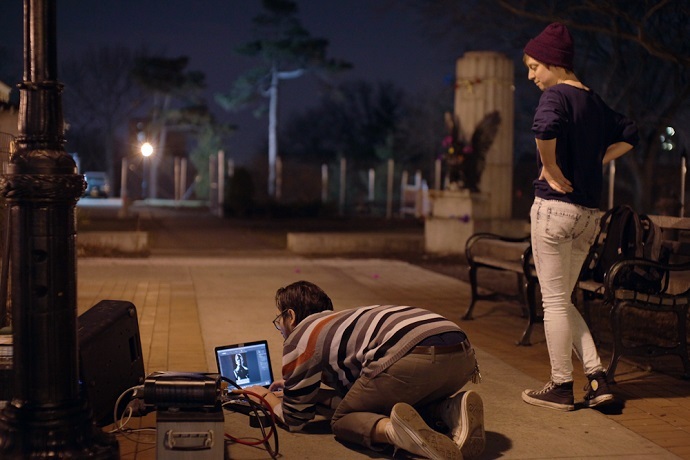 Artists with the group "The Illuminator" cast an image of Edward Snowden over the spot where a sculpture of the NSA leaker once stood on Monday, April 7, 2015. (The Illuminator)