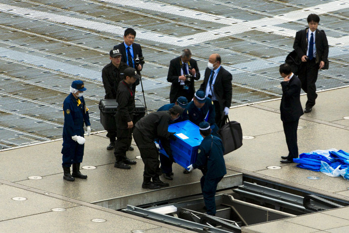 Officials carry a blue box that local media reported contains a drone from the rooftop of Prime Minister Shinzo Abe's official residence in Tokyo April 22, 2015. (Reuters / Toru Hanai)