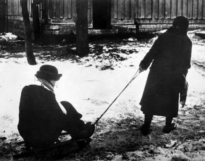 A woman sledging a starving husband in besieged Leningrad. (RIA Novosti/Israel Ozersky)