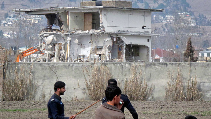 Policemen and residents stand near while demolition work is carried out on the building where al Qaeda leader Osama bin Laden was killed by US special forces in Abbottabad (Reuters / Sultan Dogar)