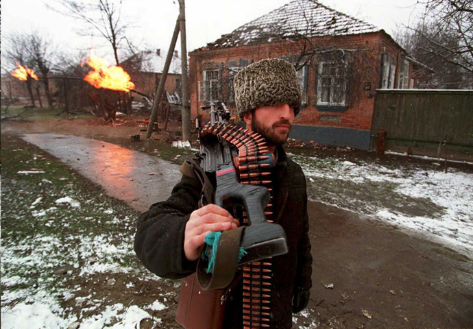 RUSSIAN FEDERATION, GROZNY: A Chechen fighter carrying a machine gun heads for downtown Grosny 17 January, 1995, as fierce fighting continue (AFP Photo)