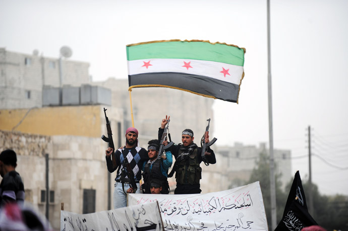 yrian rebels raise their weapons under a pre-Baath Syrian flag currently used by the opposition during an anti-regime protest in the northern city of Aleppo on March 22, 2013. (AFP Photo)