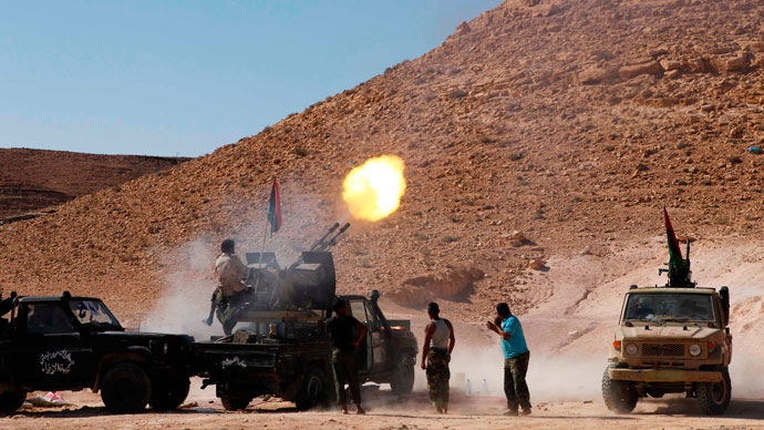 An anti-Gaddafi fighter test fires his machine gun near the frontline in the north of the besieged city of Bani Walid September 11, 2011.(Reuters / Youssef Boudlal)