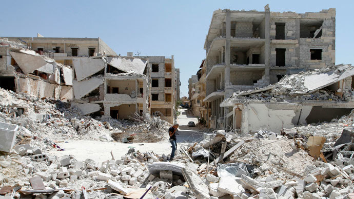 A Free Syrian Army fighter carrying his weapon, smokes as he stands on the rubble of damaged buildings in Kefr Hamra, Aleppo June 17, 2013. REUTERS/Hamid Khatib