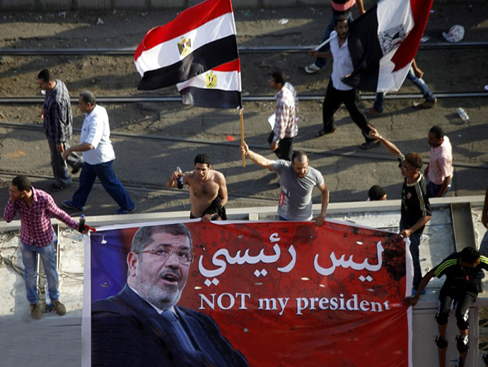 Opponents of Egypt's Islamist President Mohamed Morsi shout slogans while holding an anti-Morsi banner during a protest calling for his ouster outside the presidential palace in Cairo on June 30, 2013. (AFP Photo / Mahmud Khaled)