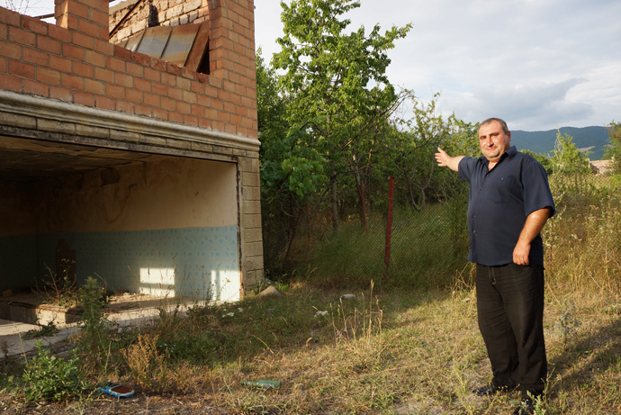 Levan shows the border fence made from his own vines. In this place, the demarcation line passes through his house (RT Photo / Nadezhda Kevorkova)