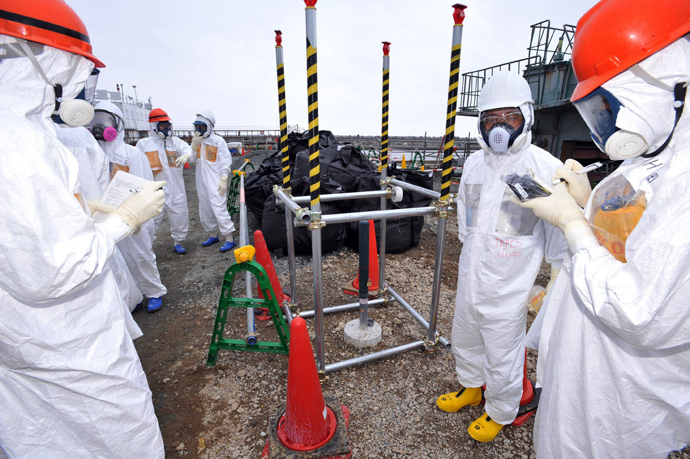 This photo taken on August 6, 2013 shows local government officials and nuclear experts inspecting a monitoring well where high levels of radioactive materials were detected at Tokyo Electric Power's (TEPCO) Fukushima Dai-ichi nuclear plant (Japan out AFP Photo / Japan Pool via JIJI Press) 