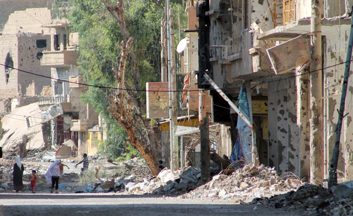 Syrians walk in a heavily damaged street in Syria's eastern town of Deir Ezzor on August 26, 2013. (AFP Photo)