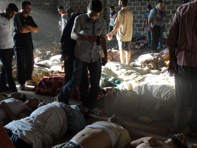 A handout image released by the Syrian opposition's Shaam News Network shows people inspecting bodies of children and adults laying on the ground as Syrian rebels claim they were killed in a toxic gas attack by pro-government forces in eastern Ghouta, on the outskirts of Damascus on August 21, 2013. (AFP/Shaam News Network)