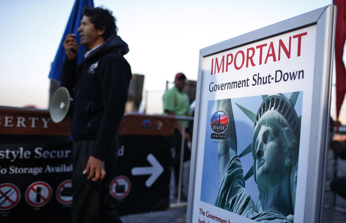 A man with a megaphone announces the closure of the Statue of Liberty, a U.S. National Park, due to the U.S. Government shutdown to tourists at the ferry dock to the Statue of Liberty in Battery Park in New York, October 1, 2013. (Reuters/Mike Segar)