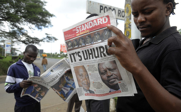 Nairobi resident read on March 31, 2013 in Nairobi the newspaper with the headline of Kenyan fourth president Uhuru Kenyatta's win, following the supreme court's decision that he was duly elected. (AFP Photo/Simon Maina)