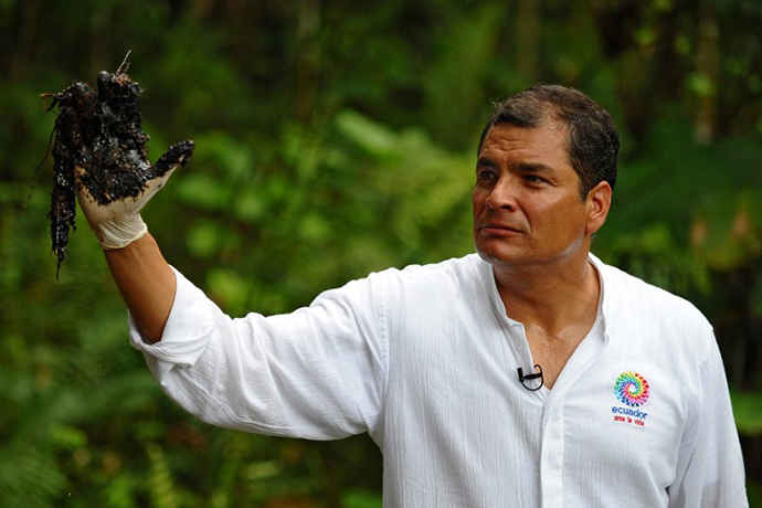 Ecuadorean President Rafael Correa shows his oil-covered hand at Aguarico 4 oil well in Aguarico, Ecuador on September 17, 2013. (AFP Photo / Rodrigo Buendia)
