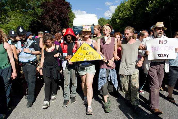 Climate and anti-fracking activists block the road in front of a tanker to delay its arrival to the test drill site operated by British energy firm Cuadrilla Resources in Balcombe, southern England, on August 20, 2013.(AFP Photo / Leon Neal)