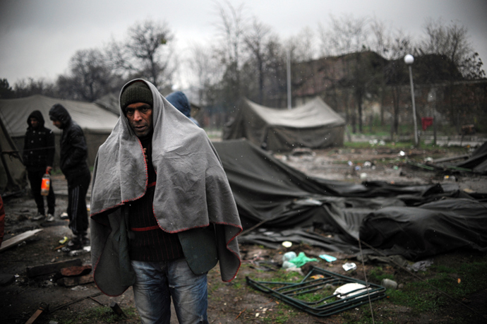 A man stands by 6 tents as snow falls in a refugee camp set in the Bulgarian town of Harmanli, south-east of Sofia, on November 27, 2013. Bulgaria's asylum centres are severely overcrowded after the arrival of almost 10,000 refugees this year, half of them Syrian (AFP Photo)