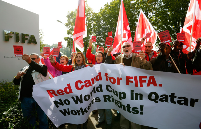 Members of the Swiss UNIA workers union display red cards and shout slogans during a protest in front of the headquarters of soccer's international governing body FIFA in Zurich (Reuters / Arnd Wiegmann)
